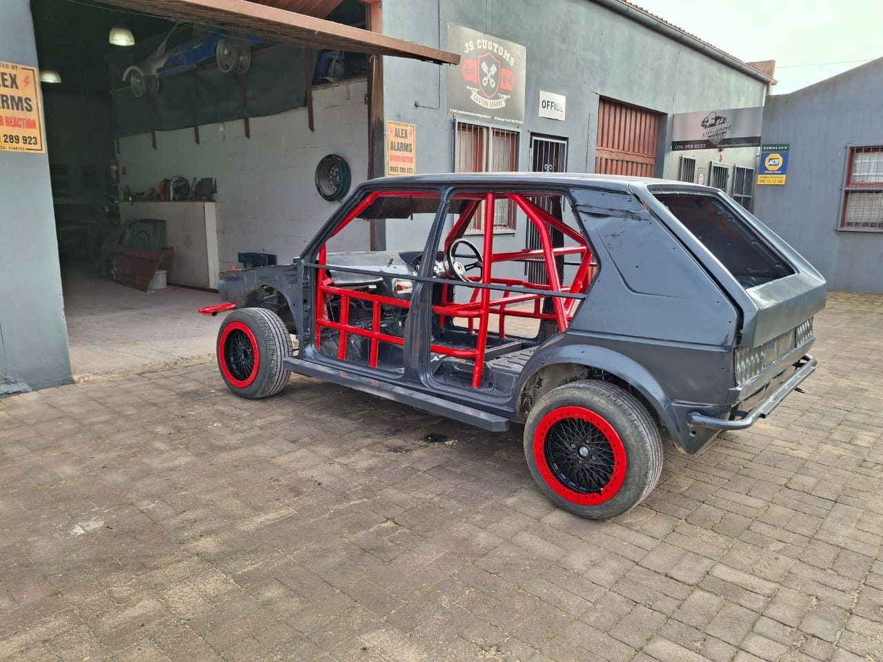 Race car shell with a newly fabricated red roll cage